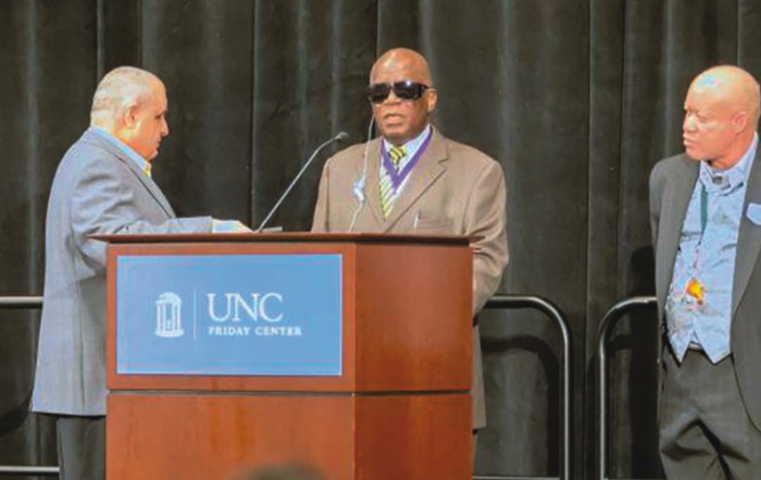 Vision impaired man speaking at a podium